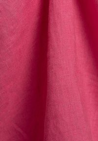 Rosa Leinenstoff mit glatter Textur, der eine leicht zerknitterte Optik aufweist. Das Material hat eine feine Webart und lässt sich leicht drapieren.