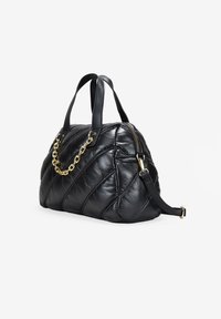 Bolso de cuero negro con textura acolchada, que cuenta con un mango negro y un acento de cadena dorada. Se incluye una correa de hombro ajustable.