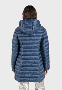 Vadderad marinblå jacka med huva, med horisontell quiltad design och glänsande yta. Lång modell, med långa ärmar och dold stängning.