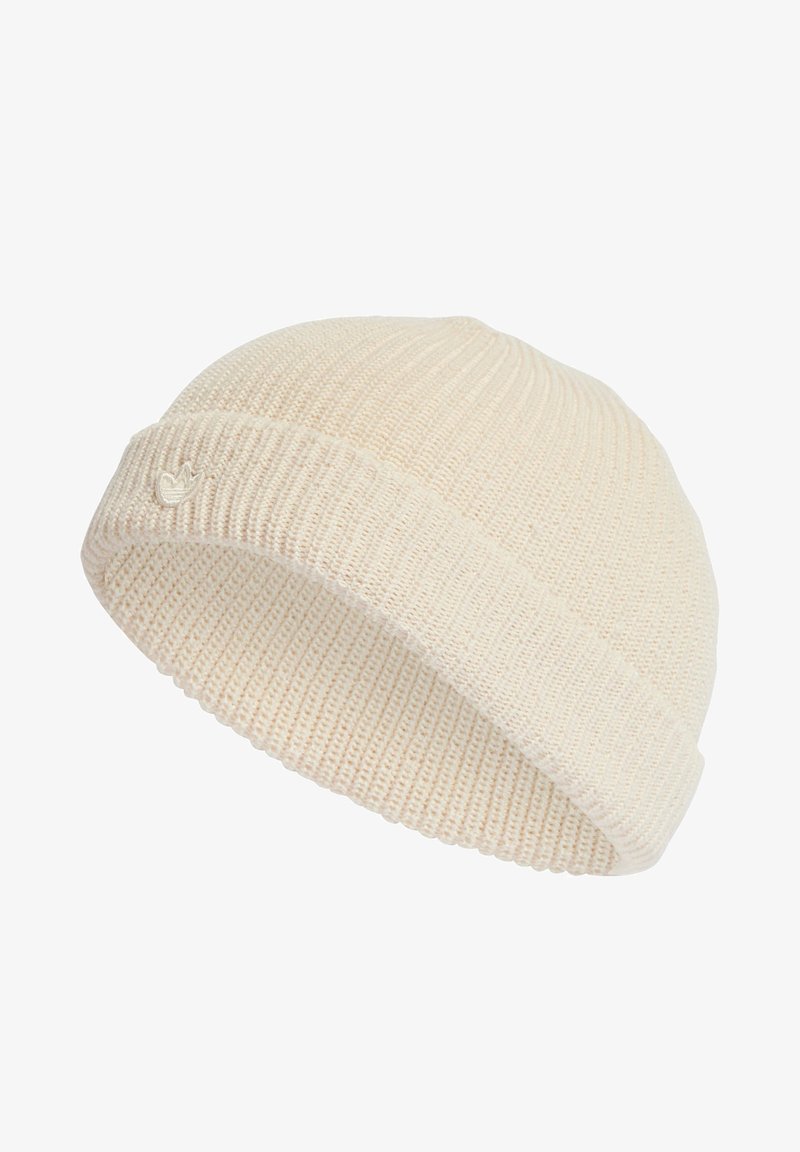 Κρεμ χρώματος πλεκτό σκουφάκι με διπλωμένο γείσο και μικρό κεντημένο λογότυπο μπροστά, παρουσιασμένο ενάντια σε λευκό φόντο.