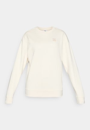 Lichtbeige sweatshirt met lange mouwen, ronde hals en geribbelde manchetten. Bevat een klein, geborduurd logo op de borst. Zachte textuur.