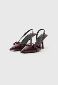 Pantofi cu toc slingback din piele lacuită burgundy, cu vârf ascuțit, curele subțiri și toc mediu stiletto. Prezintă accente decorative cu fundiță.
