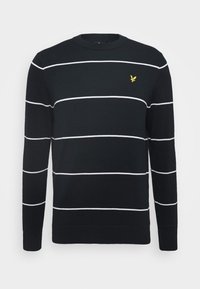 Pull noir à rayures horizontales blanches, col rond et poignets côtelés. Présente un petit détail de logo jaune sur la poitrine.