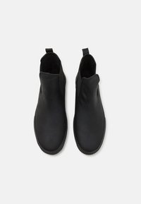 Black ankle boots made of smooth leather, featuring elastic side panels, a rounded toe, and a pull tab for easy wear. Minimal design.