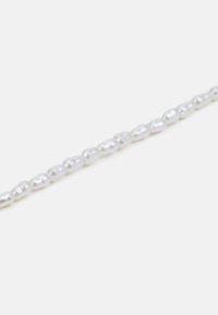 Witte parelketting met ongelijkvormige parels met een gladde, glanzende oppervlakte aan elkaar geregen in een doorlopende lijn.