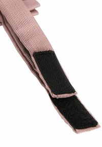 Primo piano di una cinghia in tessuto rosa con un fissaggio in velcro nero su sfondo bianco.