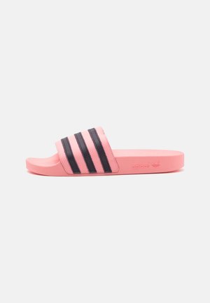 Pink slide sandal with a textured sole, featuring three black stripes across the top band and an embossed logo on the side.