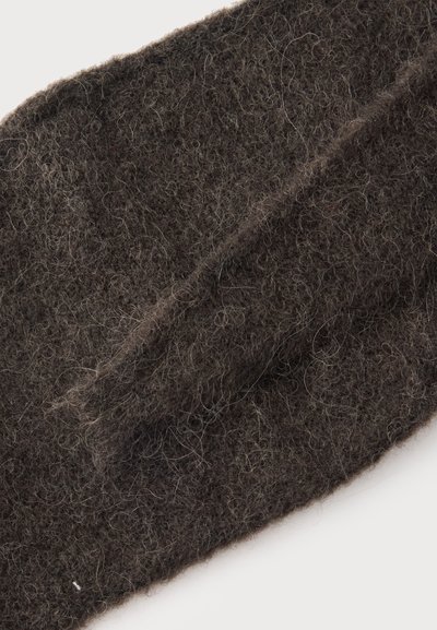 Primer plano de tejido de punto peludo de color marrón oscuro que muestra fibras suaves y texturizadas con detalles sutiles de rizado y estratificación.