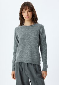 Maglione grigio a maglia con scollatura rotonda, maniche lunghe e una texture morbida. Presenta un leggero orlo a costine in vita e ai polsini.