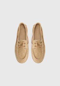 Beige-nahkakengät pyöreällä varvalla, nauhaketjulla, kontrastivärisillä ruskeilla yksityiskohdilla ja tekstuuripohjalla. Litteä kumipohja.