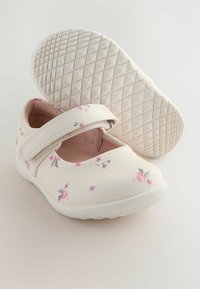 Weiße Mary Jane-Schuhe mit rosa Blumenmuster, runder Spitze, verstellbarem Riemen und gummierter Sohle mit strukturiertem Diamantmuster.