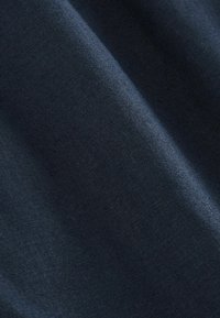 Tissu bleu marine foncé avec une texture lisse et étroitement tissée, présenté en plis doux sous un éclairage uniforme.