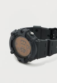 Μαύρο ψηφιακό ρολόι Casio με λουράκι από καουτσούκ, που εμφανίζει την ώρα 10:13, με κουμπιά με ετικέτες Light, Start, Mode και μπαταρία διάρκειας 10 ετών.