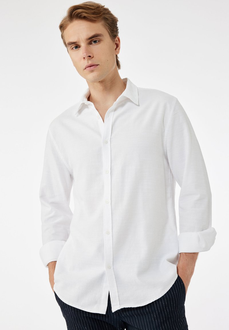 Witte blouse met lange mouwen van lichtgewicht stof, voorzien van een klassieke kraag, knoopsluiting en licht gebogen zomen.