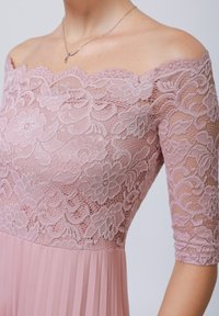 Off-the-shoulder dress featuring a detailed lavender floral lace bodice with short sleeves, transitioning to a pleated skirt in matching pastel pink.