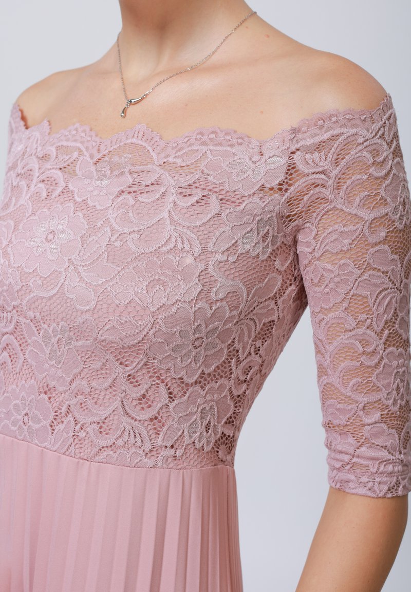 Robe décolletée aux épaules, avec un corsage floral en dentelle lavande détaillé et des manches courtes, se terminant par une jupe plissée dans un rose pastel assorti.