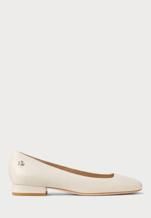 Zapato plano de mujer en piel color crema con tacón bajo, puntera redondeada y pequeño logo plateado "RL" en el lateral del talón.