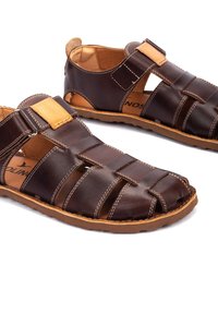 Sandalias cerradas de cuero marrón para hombre con acentos en color tostado, múltiples correas y suela de goma, mostradas lado a lado sobre un fondo blanco.