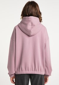 Sweatshirt roz cu glugă, cu o croială lejeră, tiv și mansete cu nervuri; textură moale și design cu umăr căzut. Vedere din spate.