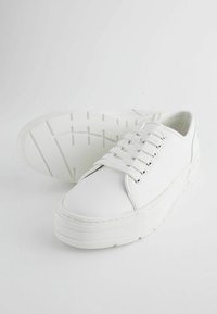 Sneakers albe cu șireturi, realizate din piele netedă, având o talpă groasă și texturată și șase găuri pentru șireturi.