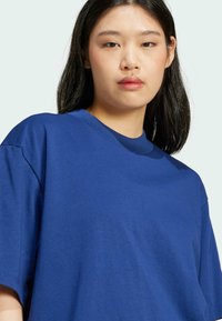 Blå bomulds T-shirt med rund halsudskæring og korteærmer. Blød tekstur med en afslappet pasform, minimal detaljer og ensfarvet.