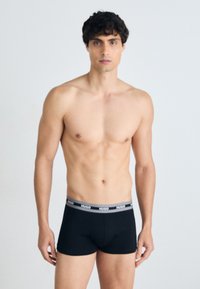 Schwarze Boxerbriefs aus dehnbarem Stoff, mit einem grauen Bündchen, das mit "HUGO"-Markenlogo versehen ist. Glatte Textur, körpernahe Passform.