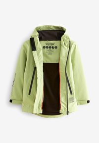 Helle grüne, wasserdichte Jacke mit schwarzem Fleece-Futter, Reißverschlusstaschen und kontrastierenden roten Akzenten. Verfügt über eine Kapuze und ein Logo auf der Innenseite.