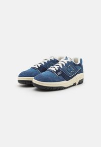 Ein Paar blaue und marineblaue Wildleder-Sneaker New Balance 550 mit weißen Schnürsenkeln und beigen Zwischensohlen auf einem weißen Hintergrund.