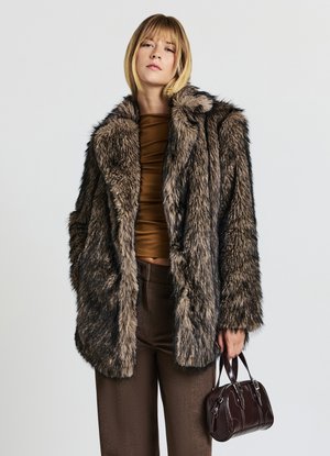 Cappotto in pelliccia sintetica nei toni marroni e grigi, con un ampio colletto e maniche lunghe. Design testurizzato a metà lunghezza. Abbinato a una borsa scura.