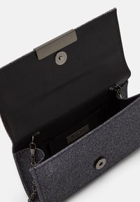 Pochette noire texturée avec une finition grise brillante, dotée d'une fermeture métallique et d'un compartiment intérieur pour les cartes et petits objets.