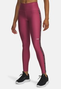 Różowe legginsy sportowe z wysokim stanem, z czarnym paskiem po boku i białym logo. Gładki, elastyczny materiał.