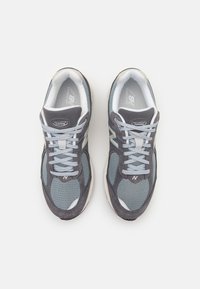 Graue und blaue Laufschuhe aus Mesh und synthetischem Material, mit einem schnürbaren Design, gepolsterter Sohle und reflektierenden Akzenten.