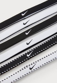 Set van elastische haarbandjes in zwart en wit, met een getextureerd design en het Nike-logo. Bevat zowel effen als gestikte patronen.