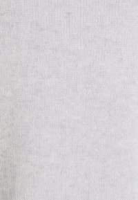 Jasnoszara dzianina o gładkiej strukturze i subtelnym wzorze rypsowym, charakteryzująca się jednolitą barwą i splotem w całej powierzchni.