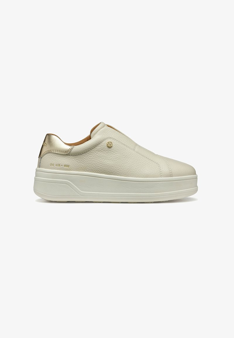 Baskets blanches en cuir à enfiler avec une finition texturée, accents métalliques dorés sur le talon et une semelle blanche épaisse. Détails de couture subtils visibles.