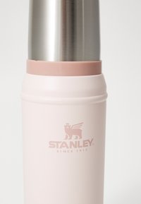 Rustfritt ståle termos med myk rosa teksturert kropp og sølv lokk. "STANLEY"-logo i matchende rosa på siden.