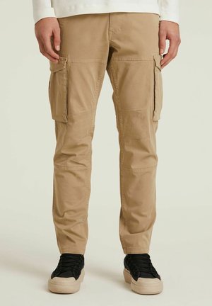 Beige cargobroek met meerdere zijzakken, taps toelopende pasvorm, gemaakt van een lichtgewicht katoenmix, met een soepele textuur en stikdetails.