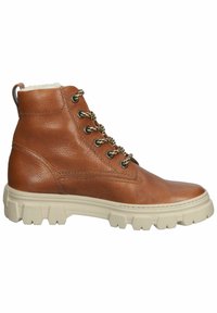 Bottine marron en cuir à lacets avec semelle épaisse blanche à crampons et doublure en polaire sur fond blanc.