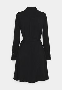 Svart klänning med långa ärmar, krage och bälte i midjan. Har veck baktill och knapppdetaljer på ärmarna. Slät, flödande tyg.