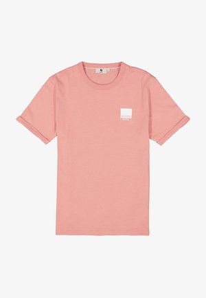 T-shirt en coton rose avec des manches courtes retroussées, un col rond et un petit logo carré blanc sur la poitrine gauche. Texture lisse.