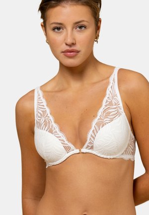 Soutien-gorge en dentelle blanche présentant un design à décolleté en V profond, des motifs floraux complexes, des bretelles réglables et un petit adorning central en ton doré.