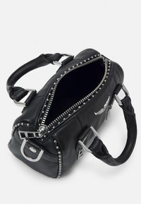 Musta nahkalaukku, jossa on hopeiset niitit vetoketjun ympärillä, kaksi kahvaa ja vetoketjulla suljettava aukko. Sisäosa on vuorattu ja tilava.