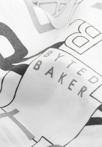 Balta auduma ar abstraktām melnā un pelēkā tipogrāfijām. Iekļauj tekstu "BY TED BAKER" izceltā veidā. Gluda virsma.