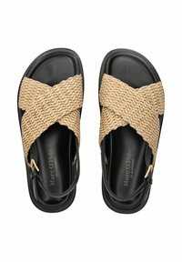Zwarte sandalen met geweven beige kruisbanden, een textuurafwerking, een slanke zool en een zijgesp detail. Fabrikantenmerk zichtbaar aan de binnenkant.