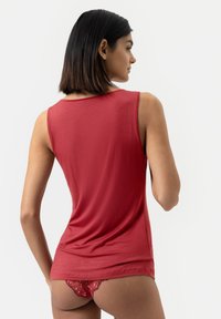 Red sleeveless top made of smooth fabric, featuring a round neckline with a relaxed fit. The back is solid without patterns or embellishments.