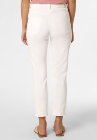 Vita denimjeans med smal passform, råa fållar och bakfickor, med medelhög midja och en mjuk textur.