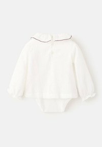 Biely dlhý rukáv body s textúrovanou tkaninou, s volánkovým golierom a kontrastným červeným ozdobným lemovaním, s dvoma gombíkmi na zapínanie vzadu.