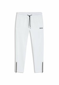 Witte sweatpants met een zwarte trekkoord en logo. Bevat zijritsen bij de enkels. Zachte textuur en taps toelopend ontwerp.