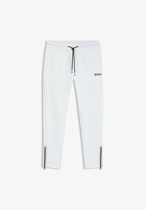 Pantaloni da jogging bianchi con cordoncino nero e logo. Presentano zip lateralmente alla caviglia. Tessuto liscio e design affusolato.