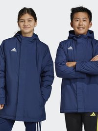 Twee kinderen dragen marineblauwe Adidas-jassen met een capuchon. De jassen hebben een ritssluiting aan de voorkant, elastische manchetten en het Adidas-logo op de borst.